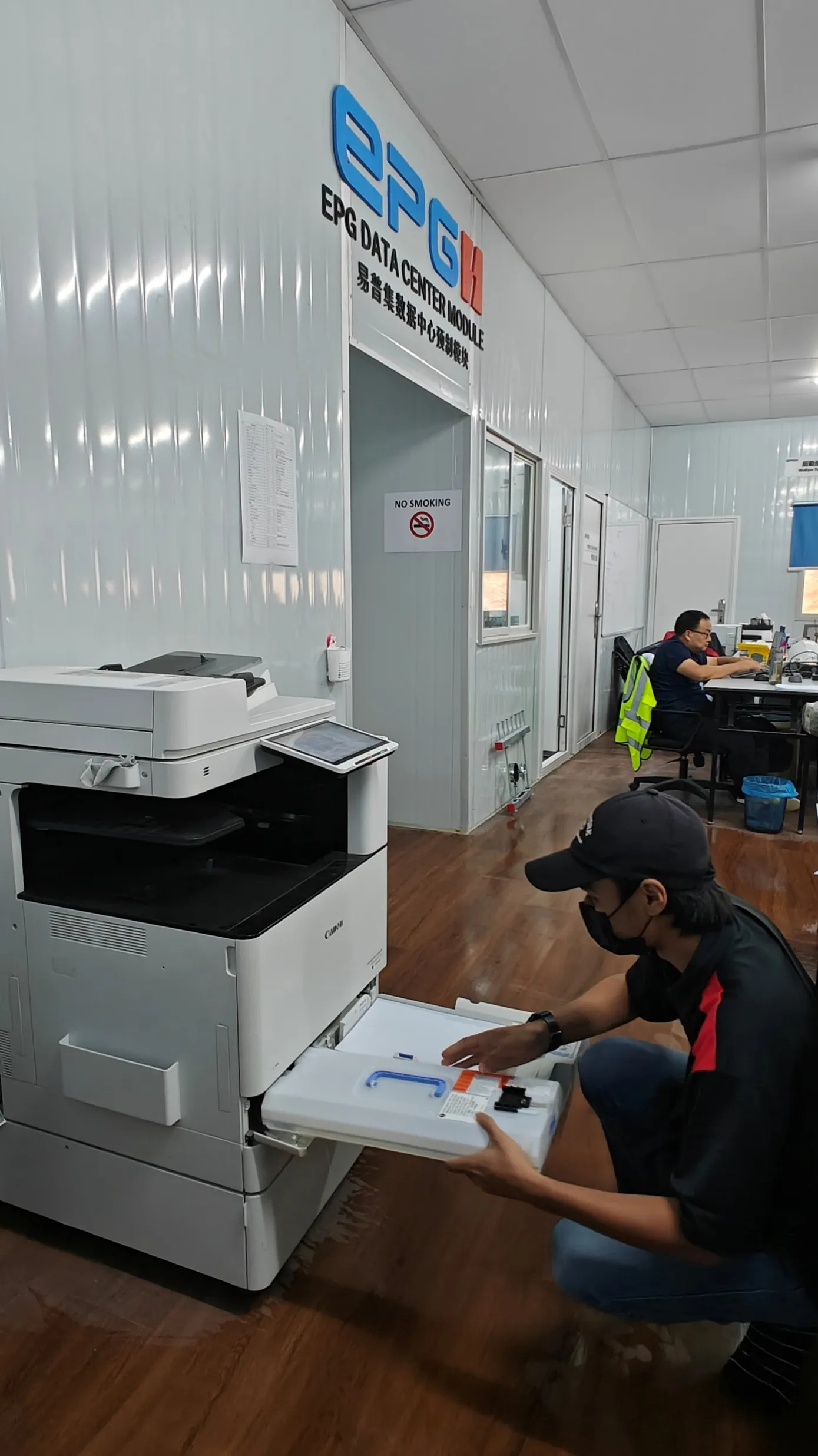 A Region technician loading paper into a copier at a data centre site office