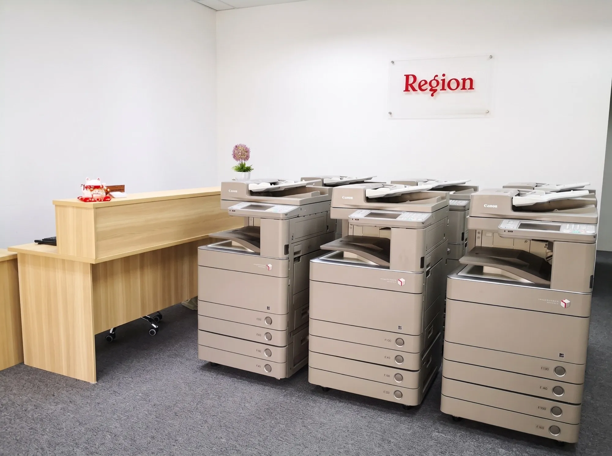 Refurbished Canon imageRUNNER ADVANCE copiers lined up under the red Region sign at the Region office in Skudai